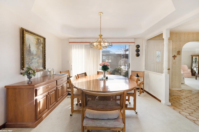 carpeted dining room with a notable chandelier