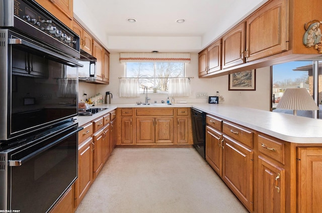 kitchen featuring black appliances, sink, and kitchen peninsula