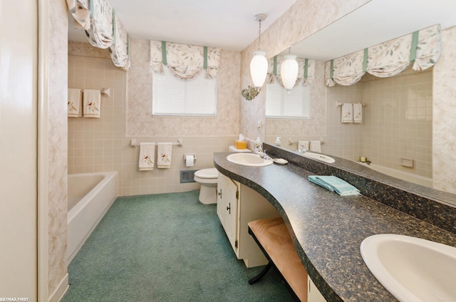 bathroom featuring tile walls, vanity, a tub, and toilet