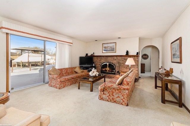 living room with crown molding, light carpet, and a fireplace