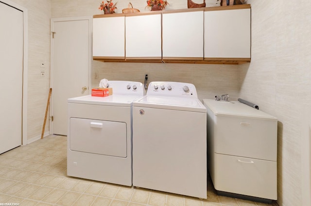 washroom featuring cabinets and washing machine and clothes dryer