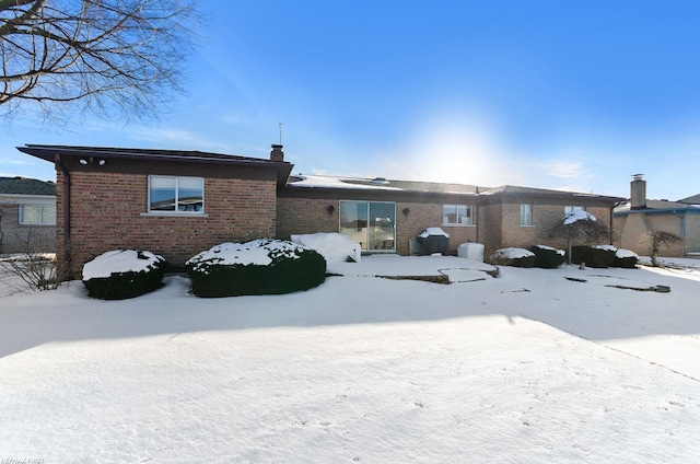 view of snow covered back of property