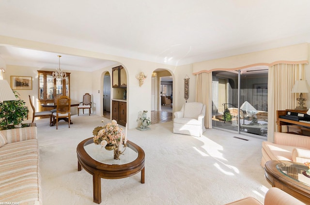 living room featuring a chandelier and light carpet