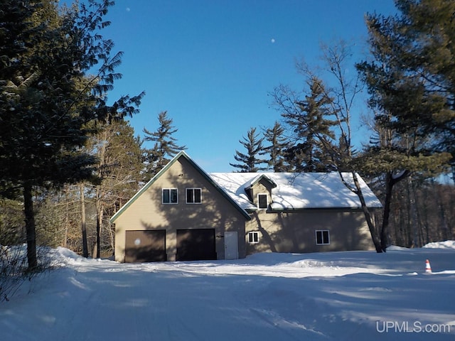 view of snow covered exterior featuring a garage