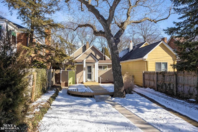 snow covered house featuring a deck