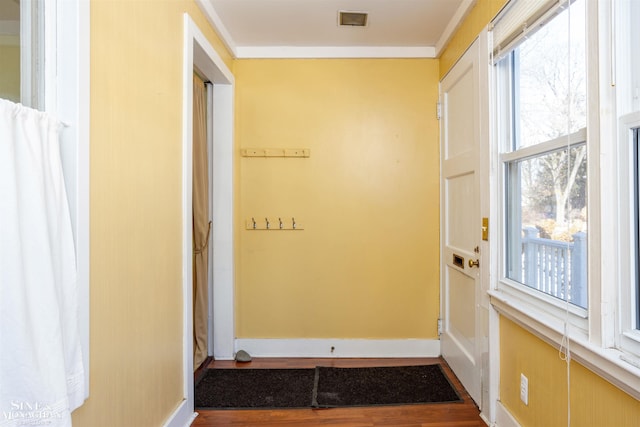 entryway with hardwood / wood-style floors, crown molding, and a healthy amount of sunlight