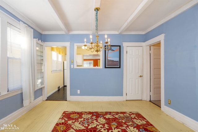 dining space featuring wood-type flooring, a chandelier, and beam ceiling