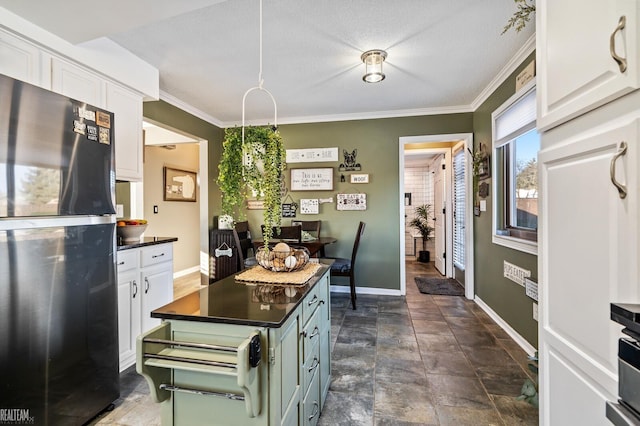 kitchen featuring crown molding, black fridge, white cabinets, and a textured ceiling