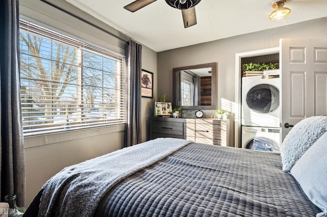 bedroom featuring stacked washer and clothes dryer and ceiling fan