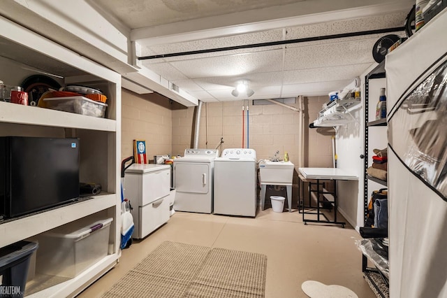 clothes washing area featuring independent washer and dryer and sink