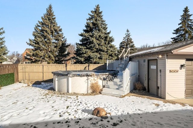 yard layered in snow with a covered pool