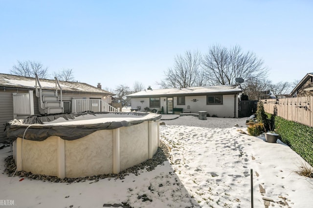 snow covered house featuring a covered pool