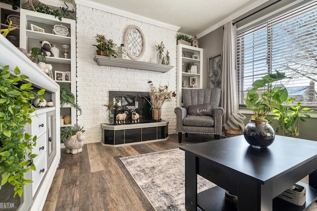 living area with crown molding, a brick fireplace, dark hardwood / wood-style floors, and a textured ceiling