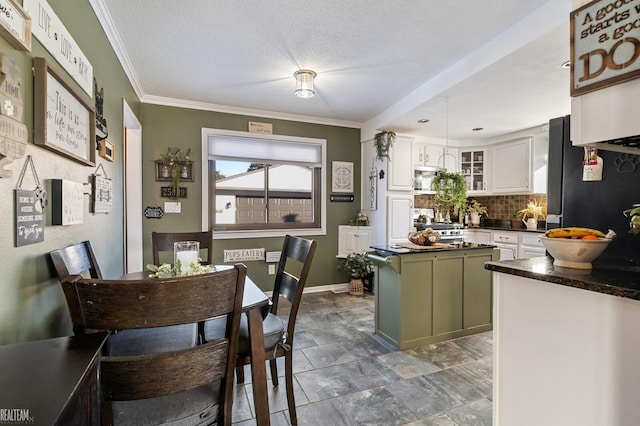 kitchen with backsplash, white cabinets, fridge, green cabinetry, and a textured ceiling