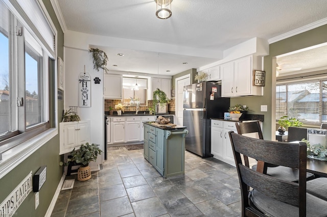 kitchen featuring white cabinetry, stainless steel fridge, a textured ceiling, and a kitchen island