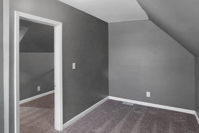 bonus room featuring vaulted ceiling and dark colored carpet