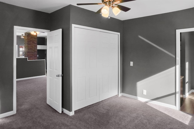 unfurnished bedroom featuring dark colored carpet, ceiling fan, and a closet