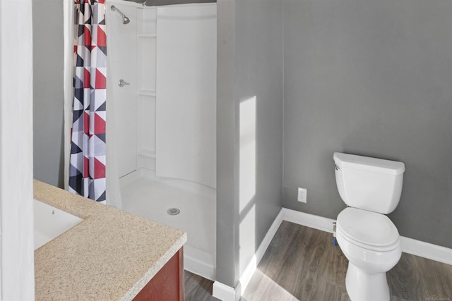 bathroom featuring hardwood / wood-style flooring, toilet, and walk in shower