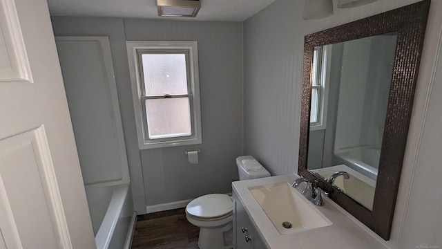 bathroom featuring vanity, plenty of natural light, hardwood / wood-style floors, and toilet