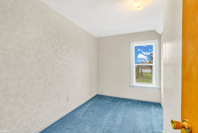 unfurnished room featuring lofted ceiling and carpet flooring