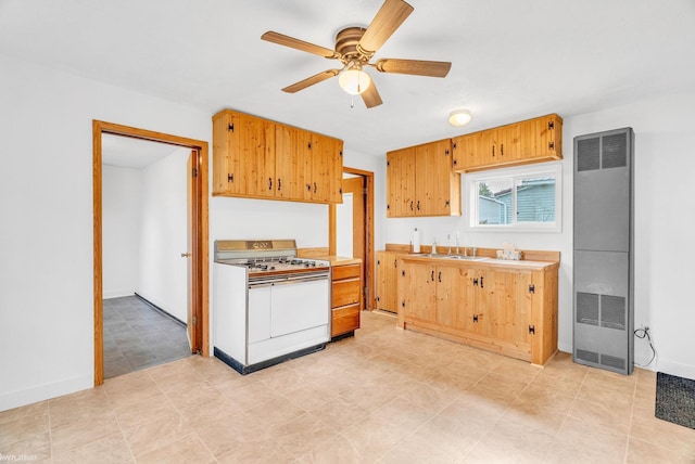 kitchen featuring ceiling fan, sink, and range with two ovens