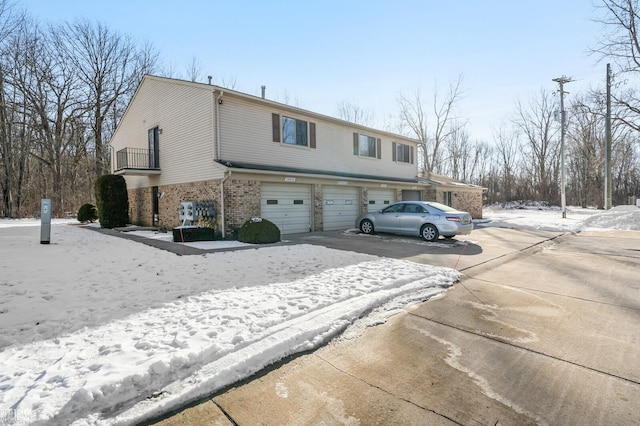 view of snow covered exterior featuring a garage