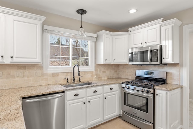 kitchen featuring light stone countertops, white cabinetry, appliances with stainless steel finishes, and sink