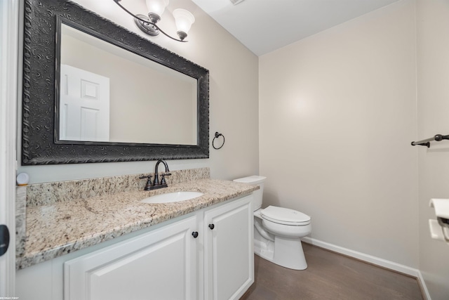 bathroom with vanity, toilet, and hardwood / wood-style floors