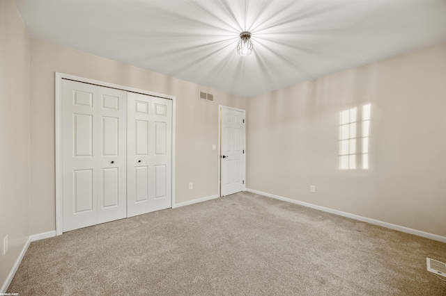 unfurnished bedroom with carpet flooring and a closet