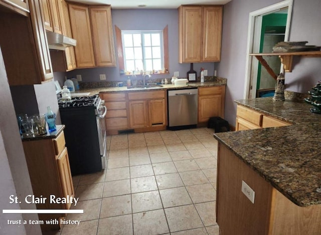 kitchen featuring dark stone countertops, sink, light tile patterned flooring, and appliances with stainless steel finishes