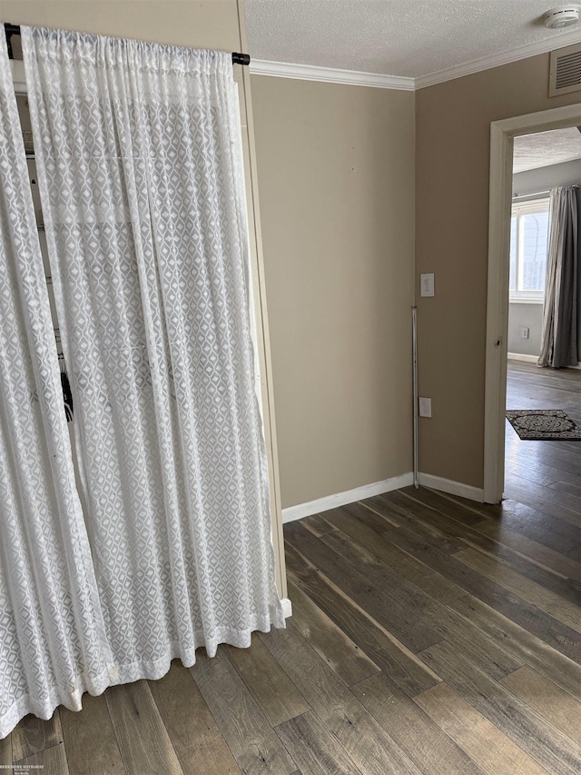 details with crown molding, wood finished floors, visible vents, and a textured ceiling