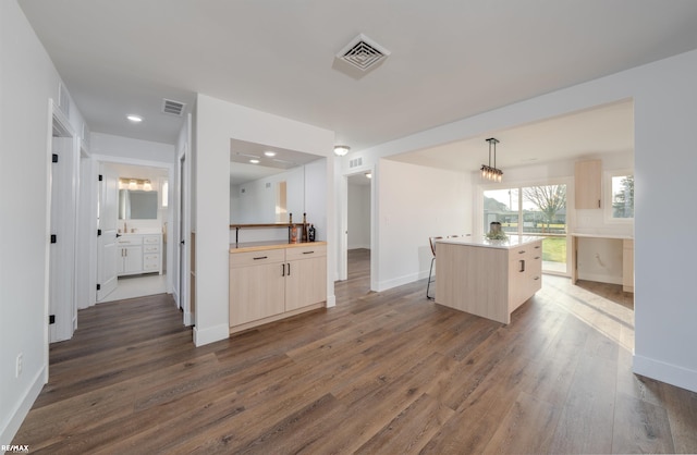 kitchen with dark hardwood / wood-style floors, hanging light fixtures, and a kitchen island