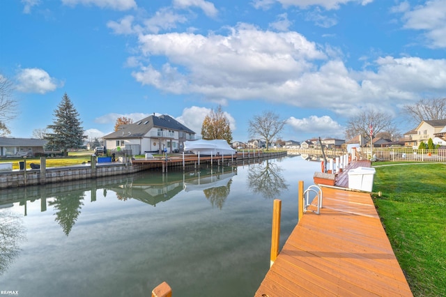 view of dock featuring a water view and a yard