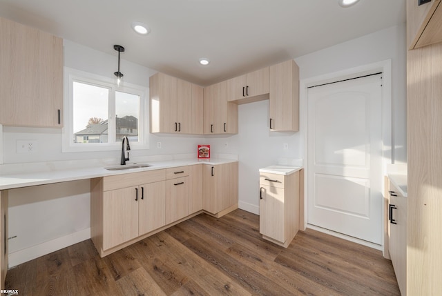 kitchen with dark hardwood / wood-style floors, decorative light fixtures, light brown cabinetry, and sink