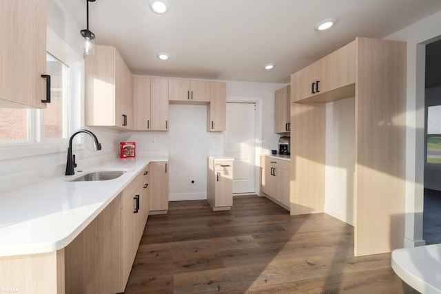 kitchen featuring sink, dark wood-type flooring, light brown cabinetry, and decorative light fixtures