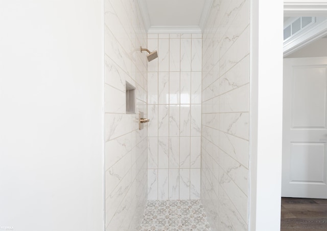 bathroom with hardwood / wood-style floors, ornamental molding, and tiled shower