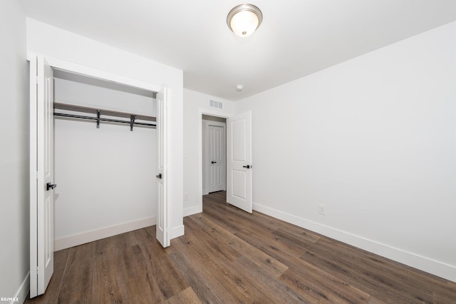 unfurnished bedroom with dark hardwood / wood-style floors and a closet