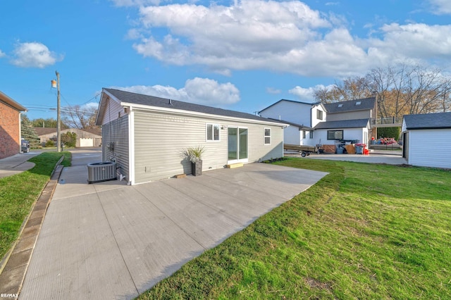 rear view of property featuring central AC, a patio area, and a lawn