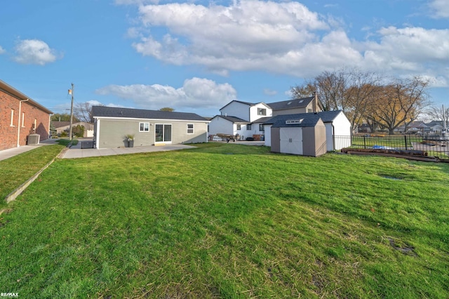 rear view of house with a storage unit, a patio area, and a lawn