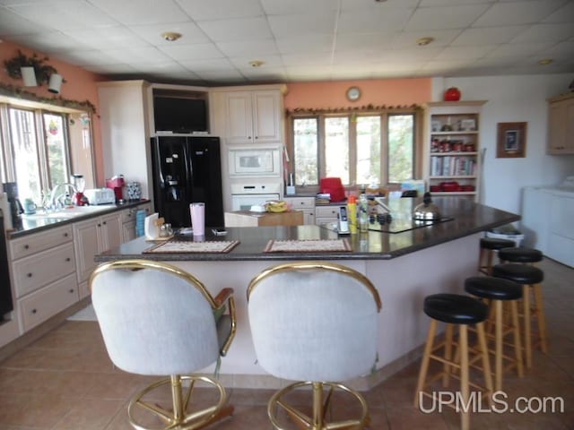 kitchen with separate washer and dryer, white appliances, a wealth of natural light, and a kitchen breakfast bar