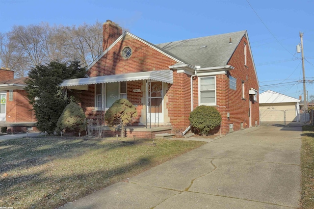 bungalow with a garage, an outdoor structure, and a front lawn