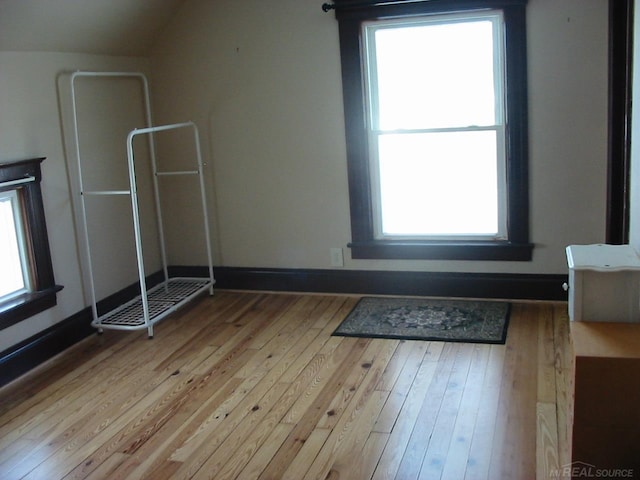 bonus room featuring lofted ceiling and light wood-type flooring