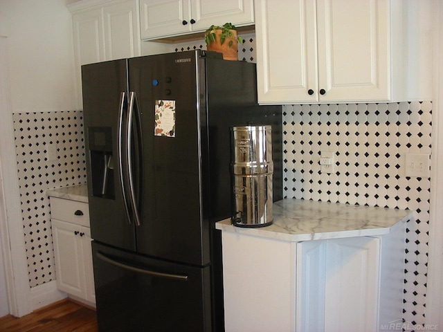 kitchen with white cabinetry, dark hardwood / wood-style floors, fridge with ice dispenser, and backsplash