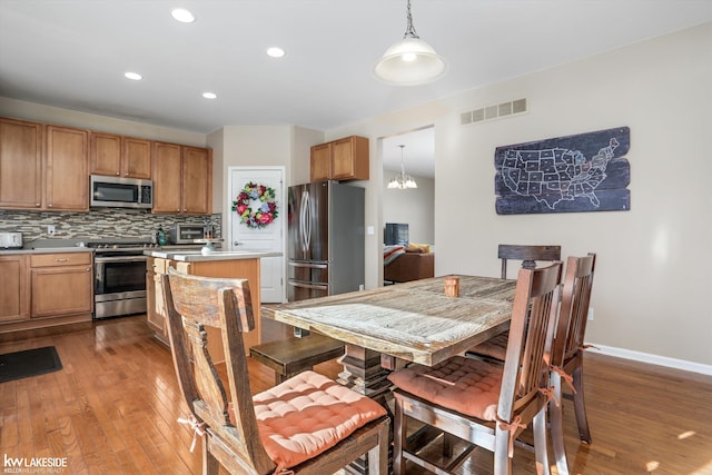 dining area featuring hardwood / wood-style flooring and an inviting chandelier