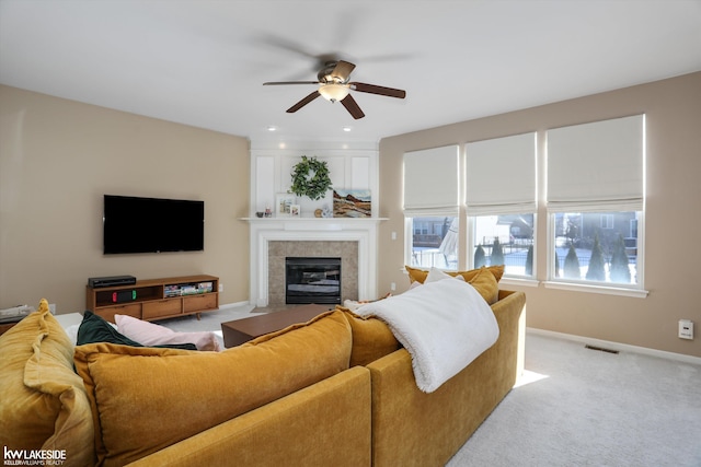 carpeted living room featuring a tiled fireplace and ceiling fan