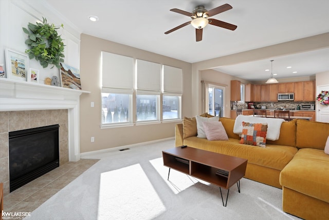 living room with ceiling fan, light carpet, and a fireplace