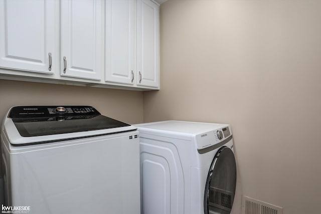 laundry room with cabinets and separate washer and dryer