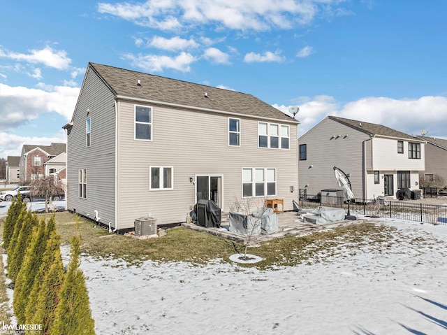 snow covered rear of property with central air condition unit