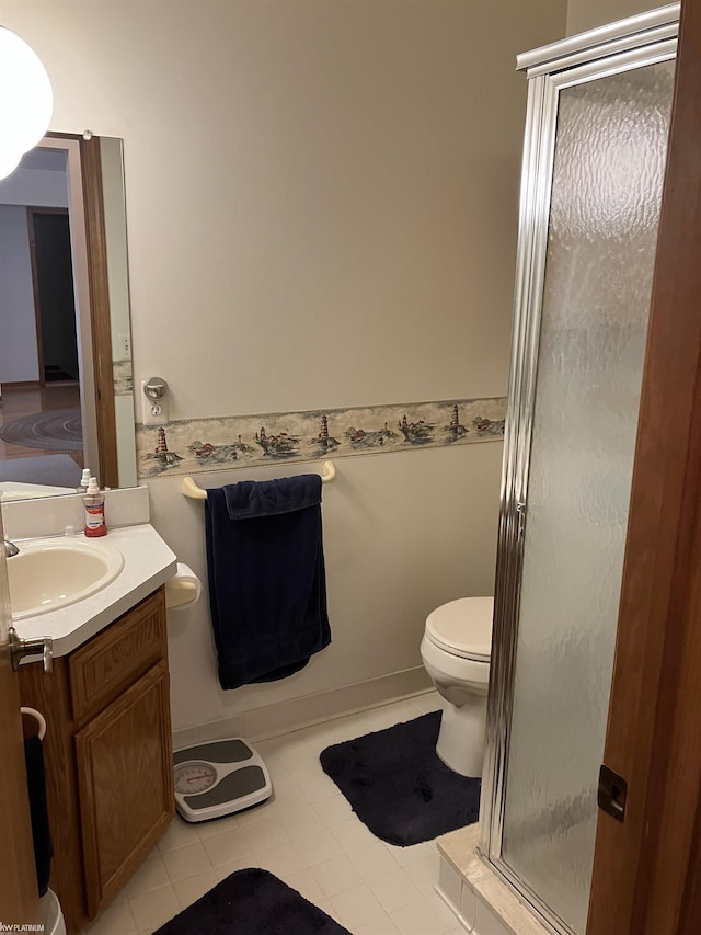 bathroom with tile patterned flooring, vanity, an enclosed shower, and toilet