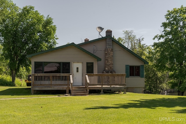 rear view of property with a wooden deck and a yard